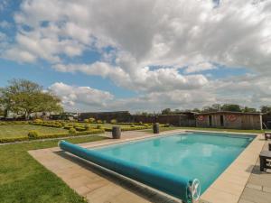 una piscina en un patio con un cielo nublado en Buckland House, en Taunton