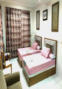 two beds in a room with a couch and a chair at فيلا رائعه في الساحل الشمالي مارينا 6 اطلاله بحر in El Alamein