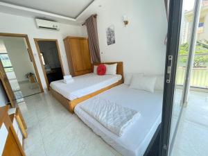 a bedroom with two beds and a glass wall at Minh Phước Villa 12 Kim Ngân in Vung Tau