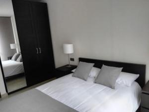 a bedroom with a white bed and a mirror at Zenit in Santa Cruz de Tenerife