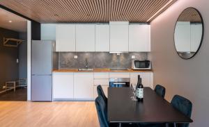a kitchen and dining room with a table and chairs at Arctic Homes - Premium Aurora Apartment in Tromsø