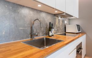 a kitchen with a sink and a counter top at Arctic Homes - Premium Aurora Apartment in Tromsø