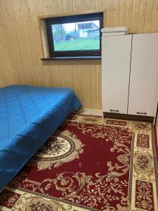 a bedroom with a bed and a window and a rug at Кольсай-Сабыржан in Saty