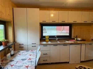 a kitchen with white cabinets and a sink and a window at Кольсай-Сабыржан in Saty