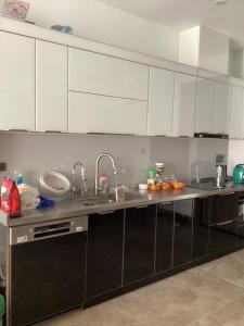 a kitchen with white cabinets and a stainless steel counter top at The MC hotel mộc châu in Mộc Châu