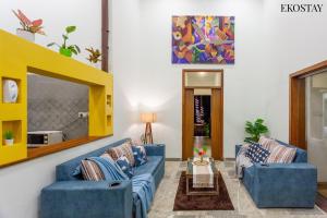 una sala de estar con 2 sofás azules y una mesa. en EKOSTAY - Sierra Villa en Alibaug