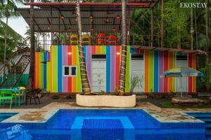 una casa colorida con una piscina frente a ella en EKOSTAY - Sierra Villa en Alibaug