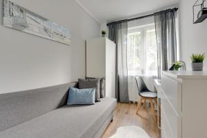 um quarto com um sofá, uma secretária e uma janela em Pokoje Gdańsk Żabianka - Gdyńska em Gdansk