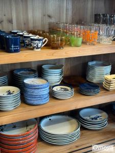 une étagère remplie d'assiettes, de bols et de tasses dans l'établissement Vacation House YOKOMBO, à Naoshima