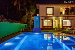 - une piscine en face d'une maison la nuit dans l'établissement EKOSTAY - Sierra Villa, à Alibaug