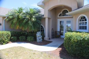 a house with a palm tree in front of it at Wildlife Views & Fishing Villa in Cape Coral