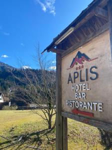 una señal para un bar restaurante de hotel en un campo en Hotel Aplis, en Ovaro