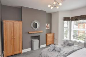Schlafzimmer mit einem Bett und einem Wandspiegel in der Unterkunft Seaside Cottage, Moments from Ryde's Golden Sands, Sleeps 4 in Ryde