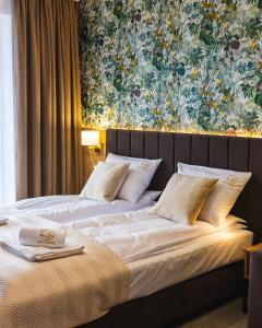 2 Betten in einem Schlafzimmer mit Wandgemälde in der Unterkunft Złoty Szałas in Zarzecze