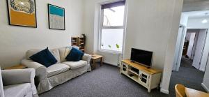 a living room with a couch and a tv at Spacious 2 Bed Flat in Central Plymouth in Plymouth