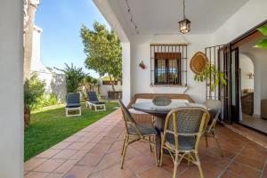 patio ze stołem i krzesłami na trawie w obiekcie Casa Dos Mares w Kadyksie