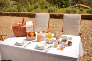 a white table with food and a basket of food at Quinta Vila Rachel - Winery in São Mamede de Riba Tua