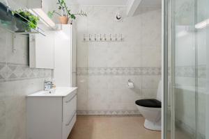 uma casa de banho com um WC, um lavatório e um chuveiro em Boukersen Heim em Tromsø