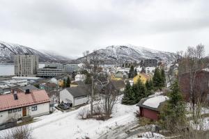 a town covered in snow with mountains in the background at Boukersen Heim in Tromsø