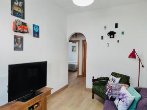 a living room with a flat screen tv and a couch at Pátio 7 & Meio DiscoverAlentejo in Moura