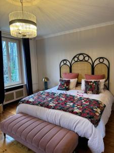 a bedroom with a large bed and a chandelier at Le Clos des Fées in Asnières-sur-Oise
