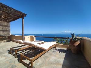 un balcón con un sillón y el océano en Home in Kea en Ioulida