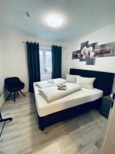 Rhein Appartements في رينهاوسن: غرفة نوم بسرير كبير مع ستائر زرقاء
