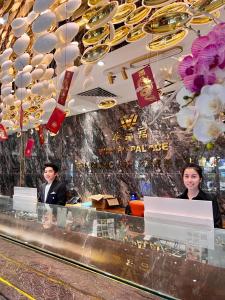 two people standing behind a counter in a restaurant at Wah Fu Hotel in Ho Chi Minh City