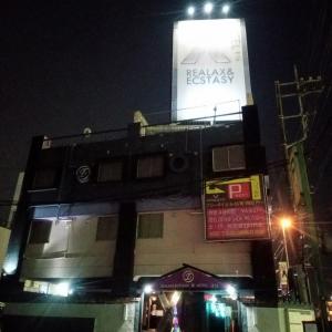 un edificio con un cartel en su costado por la noche en X ホテル（レジャーホテル） en Sayama