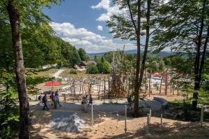 grupa ludzi spacerujących po placu zabaw w parku w obiekcie Ferienwohnungen Bayerwaldblick im Ferienpark Geyersberg w mieście Freyung