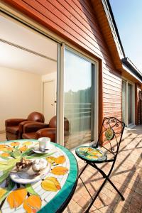 a table and chairs on a patio with a glass door at Logis L'Auberge - Maison Glenn Anna in Sainte Anne d'Auray  +23 photos