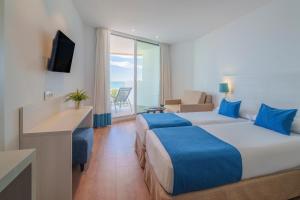 ベナルマデナにあるHotel Benalmadena Beachのベッド2台とバルコニーが備わるホテルルームです。