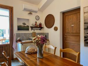 una cucina con tavolo in legno e vaso di fiori di Stagnone Area Zero a Birgi Vecchi