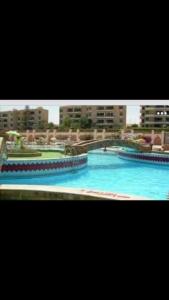 - une grande piscine d'eau bleue dans un bâtiment dans l'établissement القاهره, à Ḩulwān