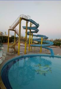une grande piscine avec un toboggan dans l'établissement القاهره, à Ḩulwān
