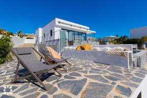 - deux chaises assises au-dessus d'une terrasse dans l'établissement Villa Nautilus by Abahana Villas, à Benissa