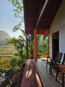 a porch of a house with a view of a field at Sinharaja Cabana in Matara
