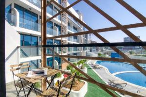 an apartment balcony with a view of a swimming pool at The Smart Concierge - Samana Hills in Dubai