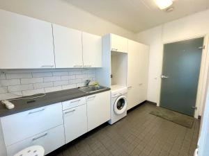 a kitchen with a sink and a washing machine at Apartment Isorannantie in Pyhäjoki