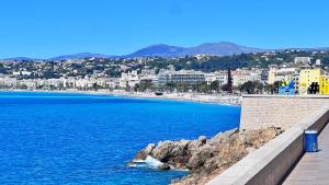 a view of a beach with buildings and the ocean at Le Syrius in Nice