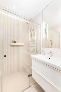 baño blanco con ducha y lavamanos en Apartament Krucza by Your Freedom, en Varsovia