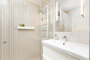 y baño blanco con lavabo y ducha. en Apartament Krucza by Your Freedom, en Varsovia