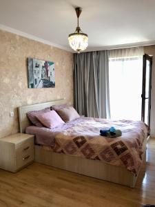 Schlafzimmer mit einem Bett und einem Kronleuchter in der Unterkunft Homee in Tbilisi City