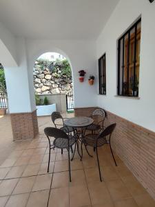 einen Tisch und Stühle auf einer Terrasse mit Ziegelwand in der Unterkunft El mirador del beregenal in Enix