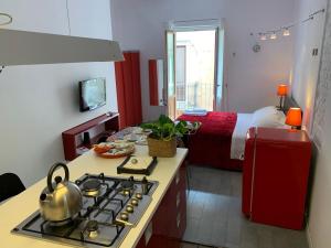 eine Küche mit einem Herd und ein Zimmer mit einem Bett in der Unterkunft Guest house Le Sibille in Taormina