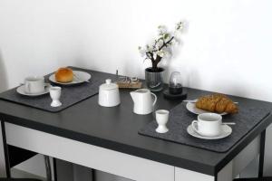 a black table with cups and plates of food on it at Ferienwohnungen Bayerwaldblick im Ferienpark Geyersberg in Freyung
