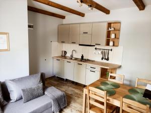 a kitchen and dining room with a table and a couch at przy lesie in Białowieża