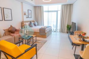 a living room with a bed and a dining room at Spacious Studio In Thalassa in Abu Dhabi