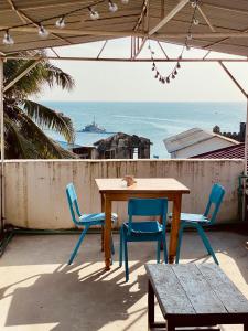 - une table et des chaises sur une terrasse donnant sur l'océan dans l'établissement Balcony House, à Zanzibar City