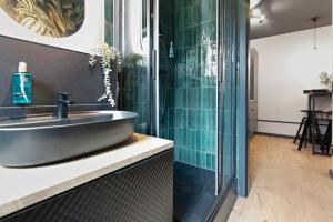La salle de bains est pourvue d'un lavabo et d'une douche en verre. dans l'établissement Flatista Homes - Jungle House, à Munich